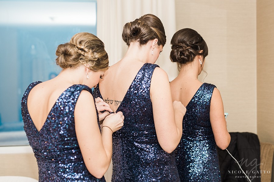 bridesmaids zipping up their dresses