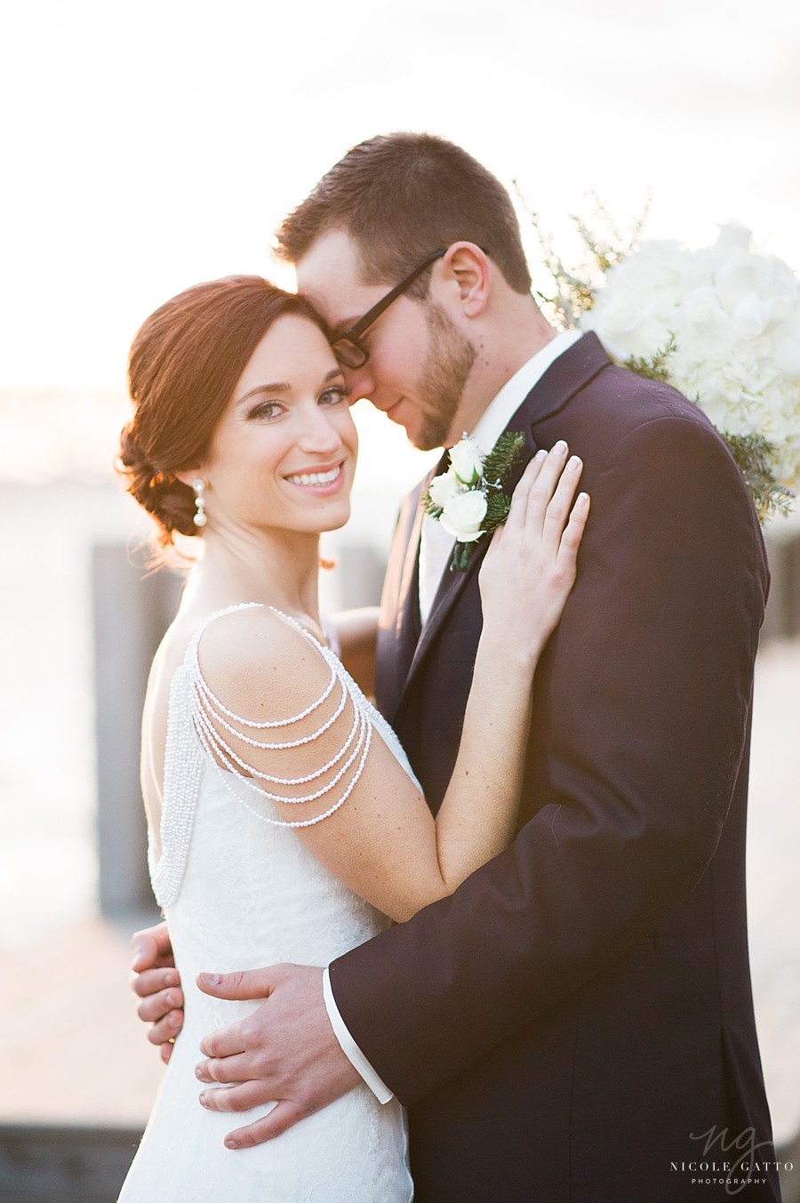 bride smiling directly at camera with groom hugging her in wedding photography buffalo ny