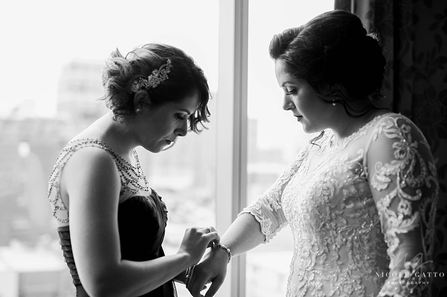 Wedding at The Embassy Suites brides sister putting on bracelet