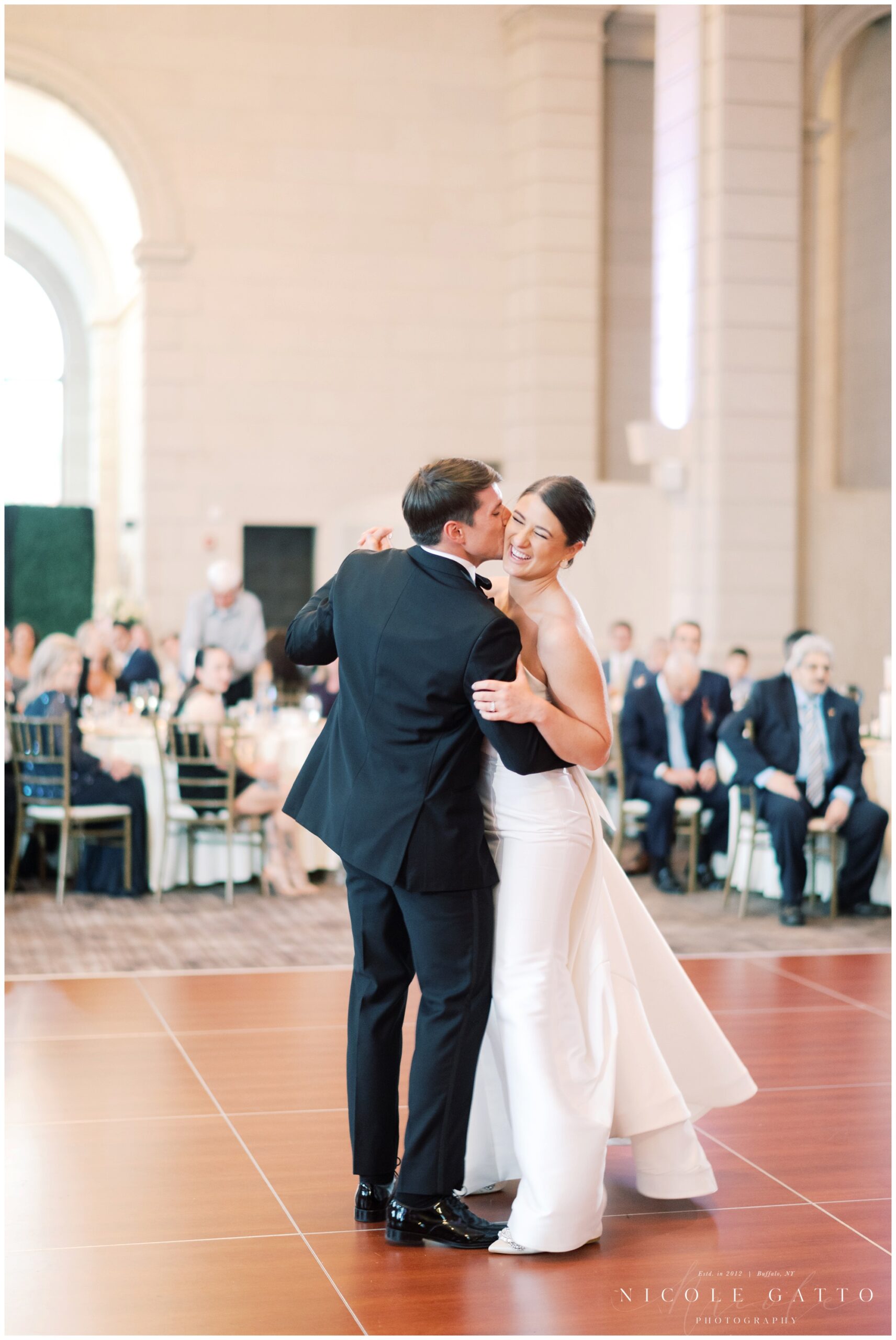 groom kissing bride on cheek during first dance at the admiral room 