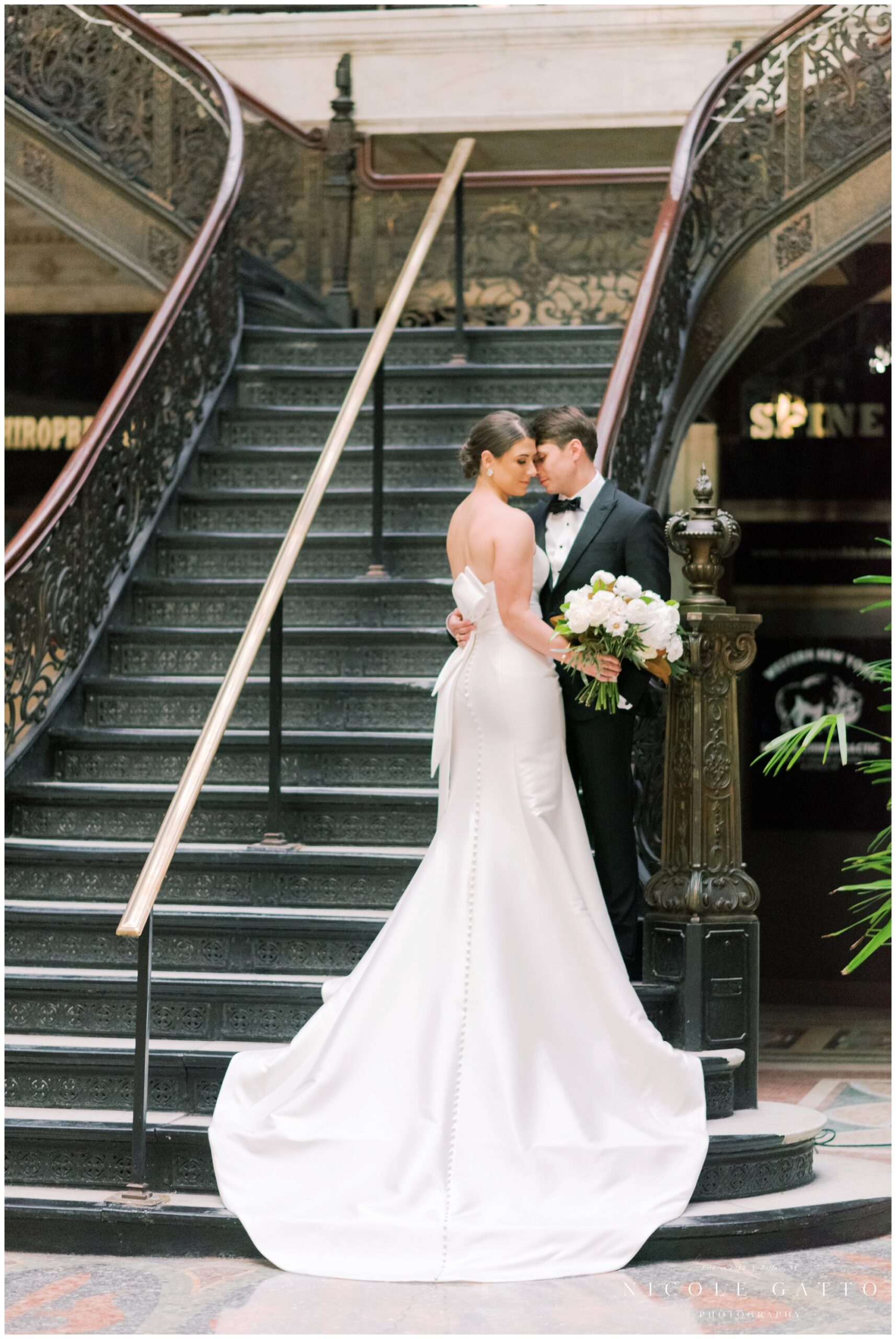 bride and groom posing on stair case at the ellicott square building buffalo ny