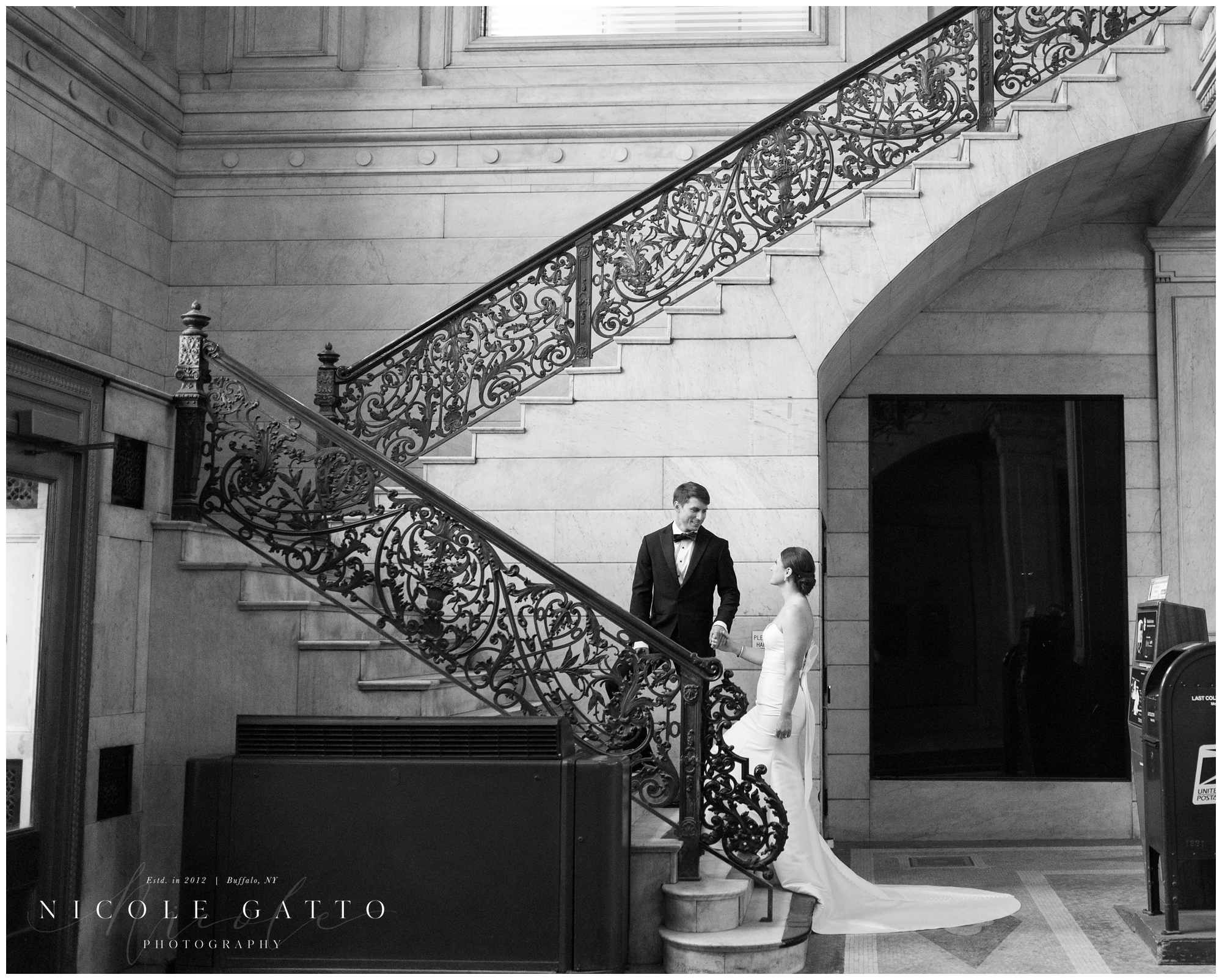 bride and groom walking up stairs from wedding at the eliicott square building buffalo ny