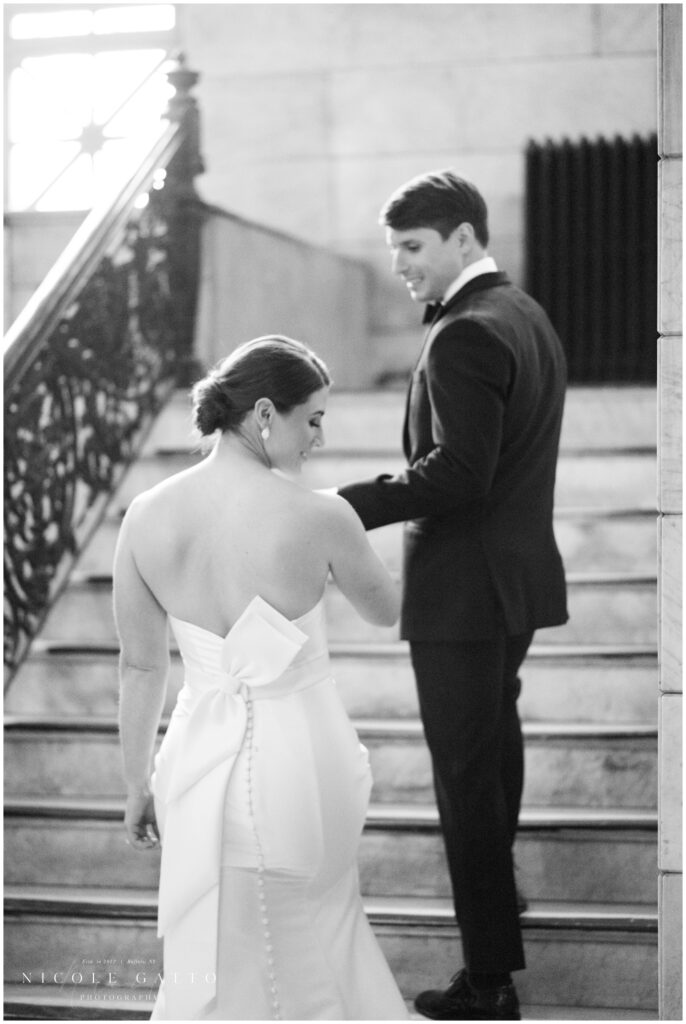 bride and groom walking up stairs from wedding at the eliicott square building buffalo ny