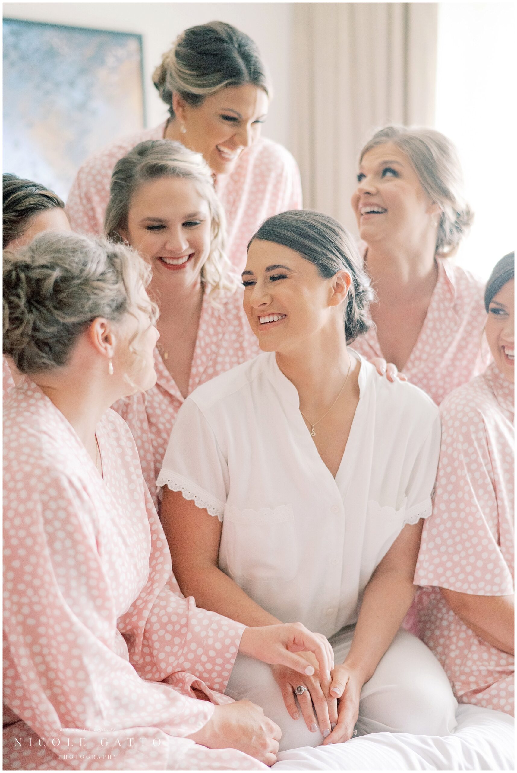 bride and bridesmaids on bed in matching robes in buffalo ny