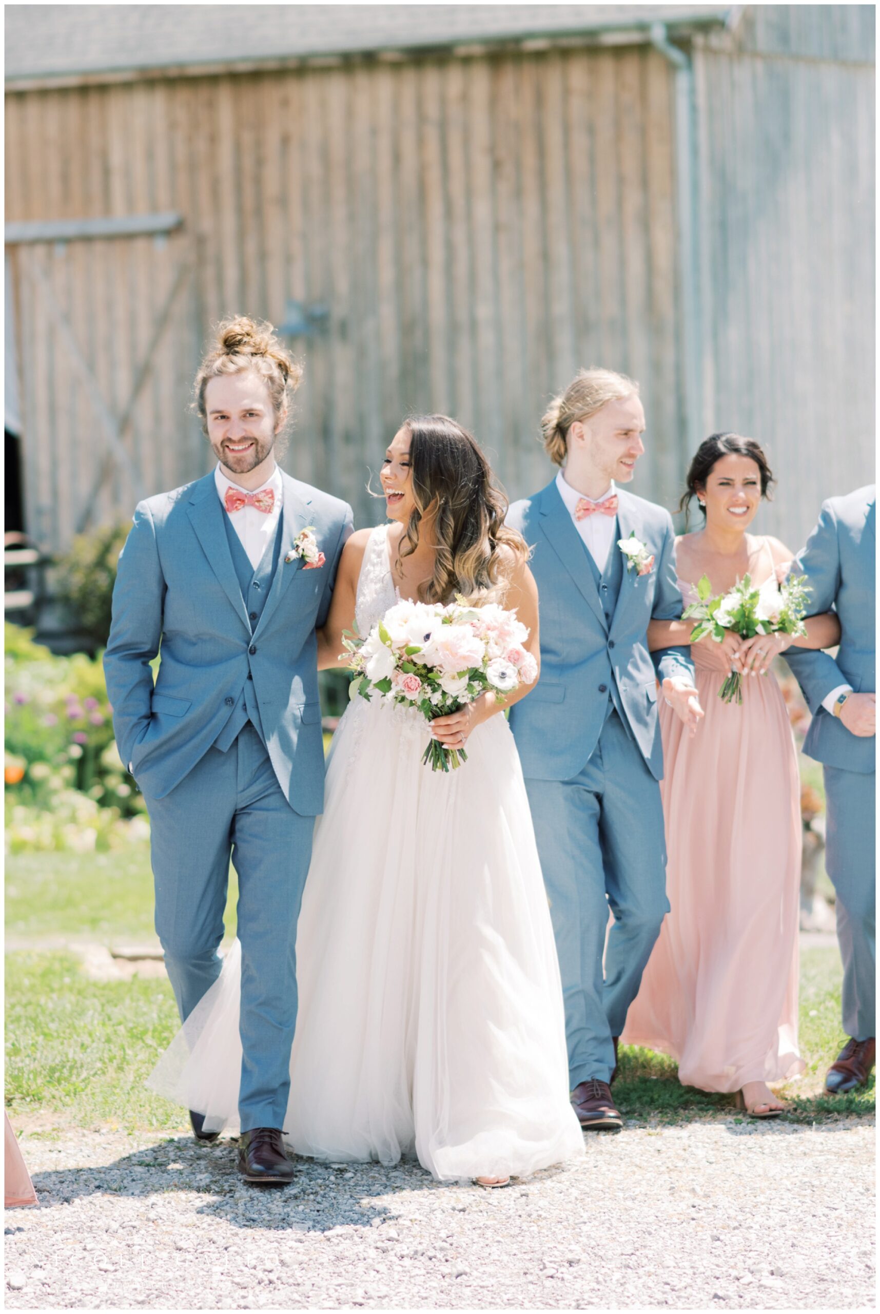 bride and groom walking in front of barn at hayloft in the gove in eden ny