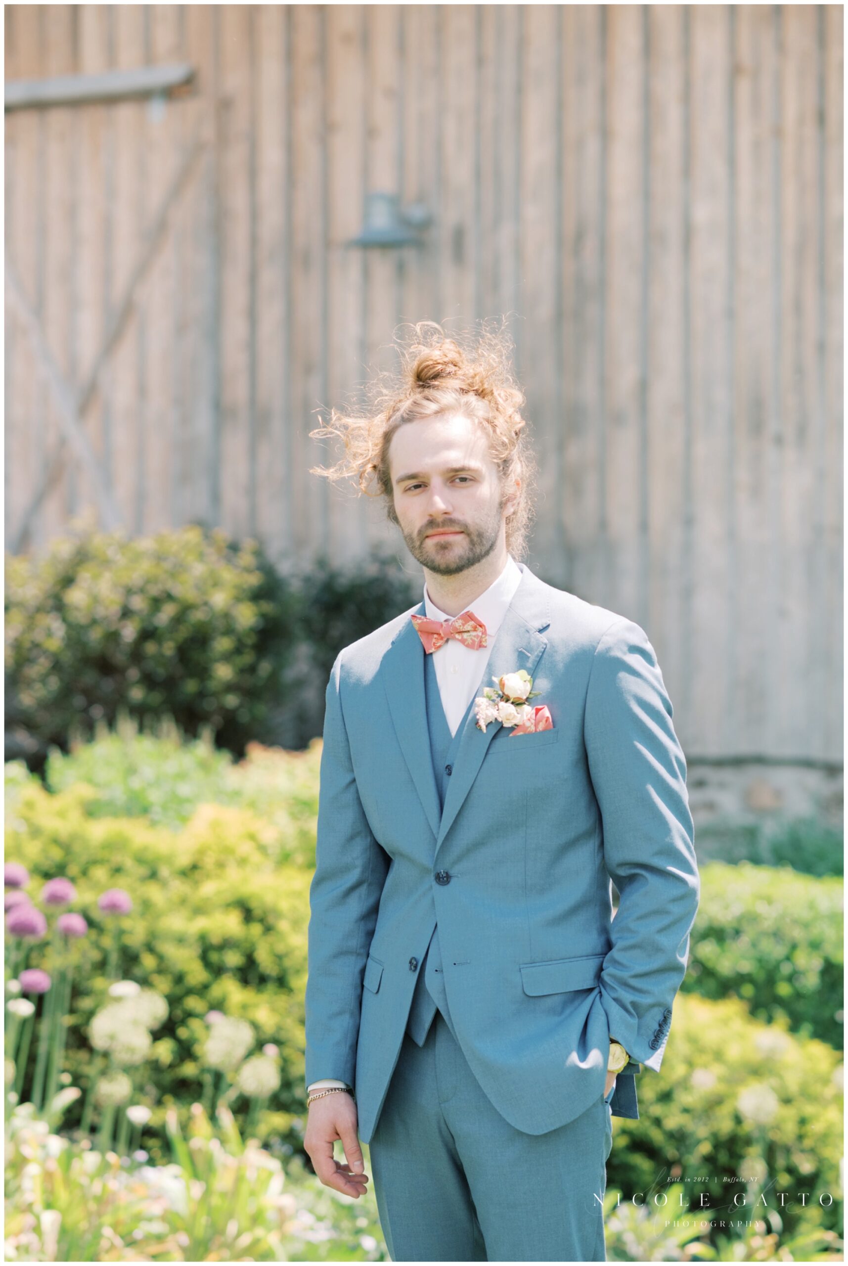 groom by himself in front of barn